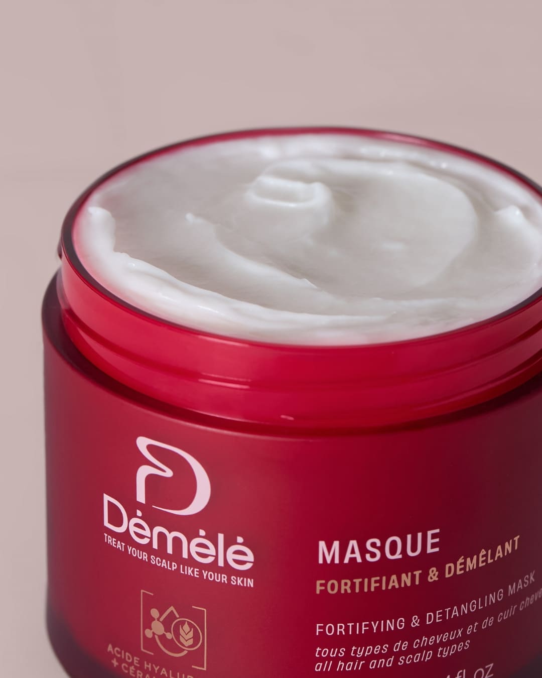 Masque fortifiant et démêlant pour cheveux, contenant des ingrédients nourrissants, dans un pot blanc avec étiquette.